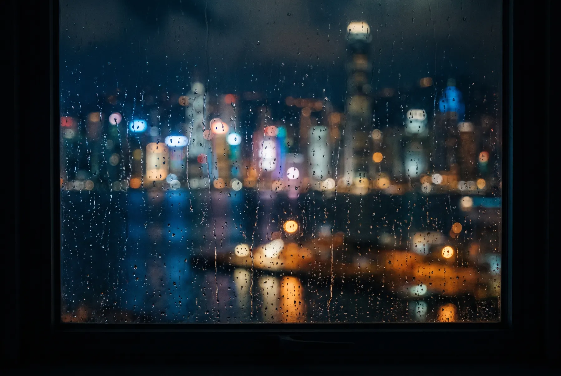Rain on an office window, the lights of Victoria Harbour out of focus beyond it